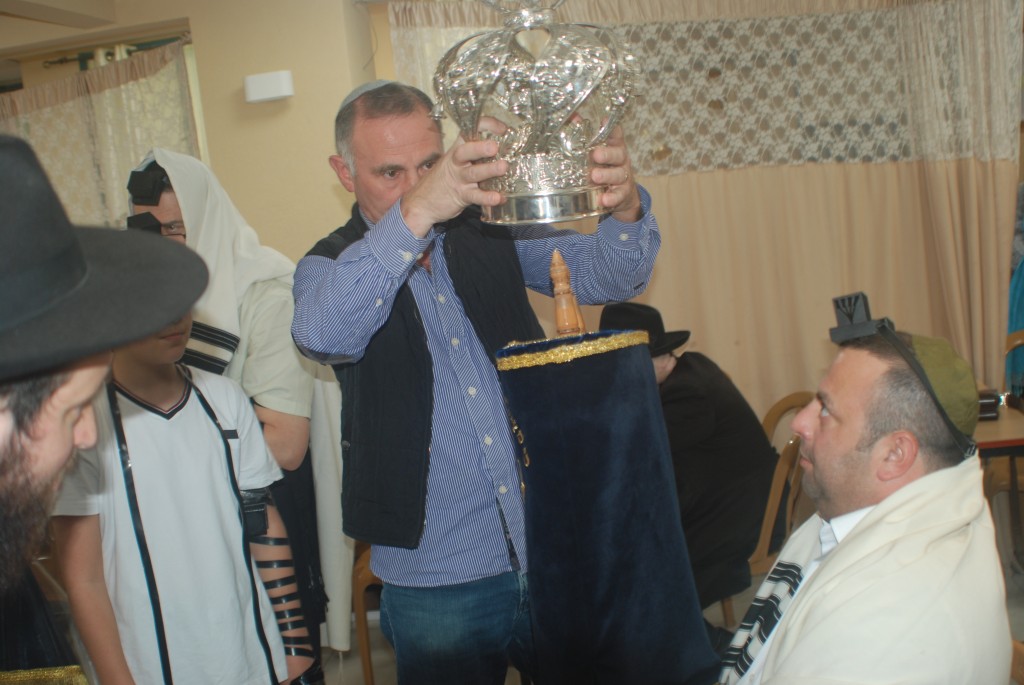 Родственник семьи Шлифер одевает корону на свиток Торы Родственник семьи Шлифер одевает корону на свиток Торы
